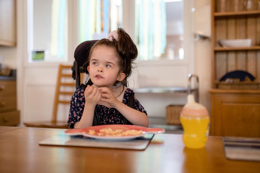 Girl eating a snack at a dining table